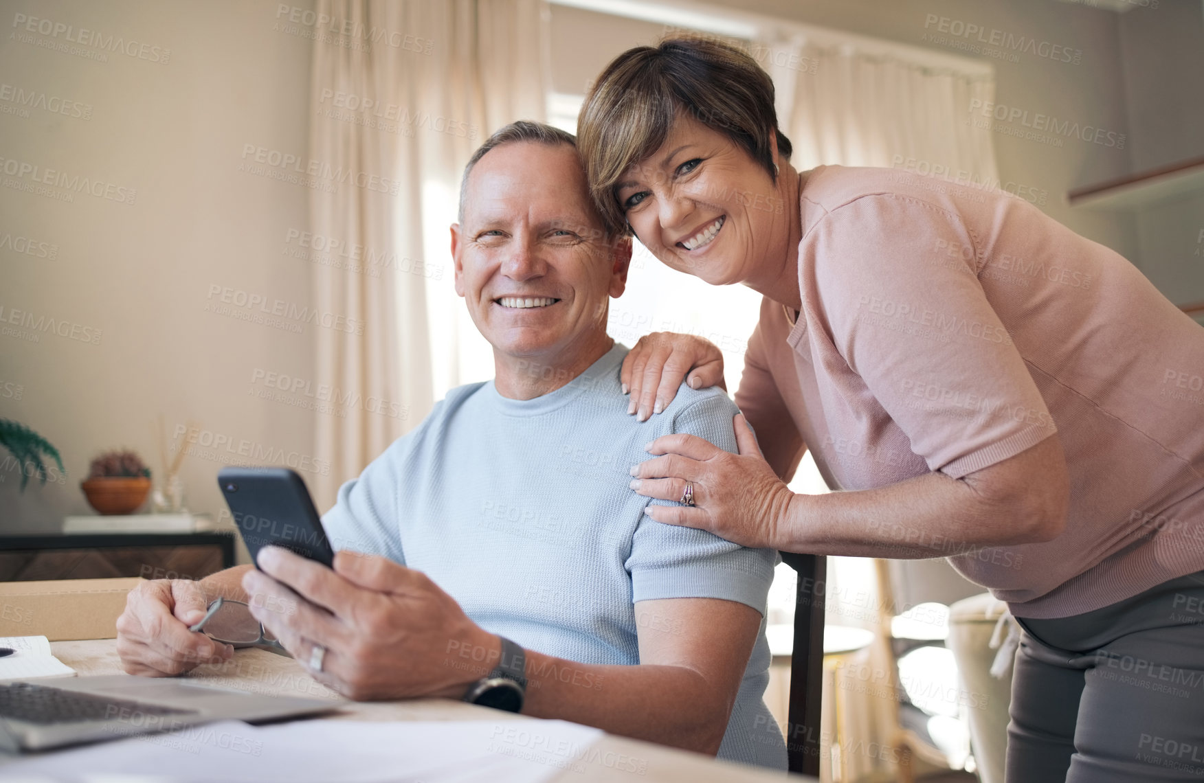 Buy stock photo Shot of a mature husband and wife together using a smartphone