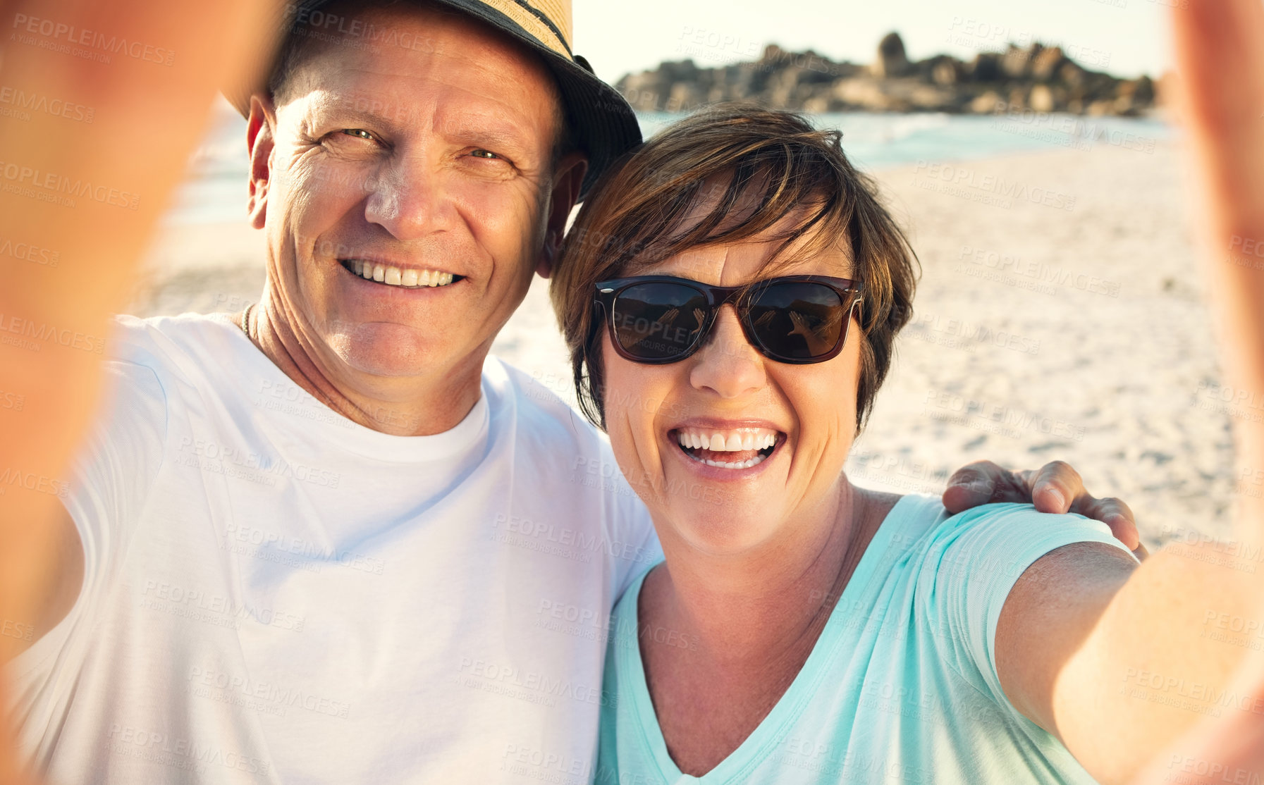 Buy stock photo Shot of a mature couple taking a selfie while spending the day at the beach