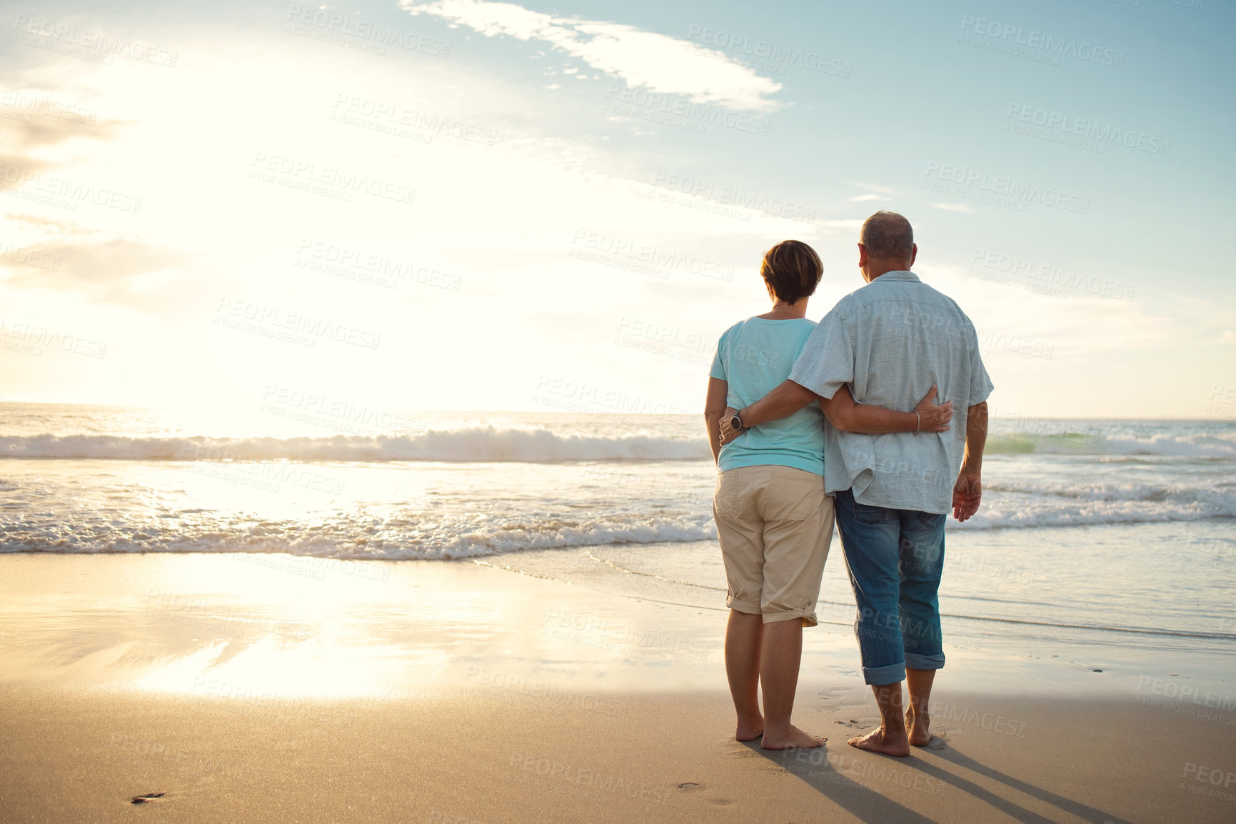 Buy stock photo Rearview shot of a couple admiring the view while at the beach