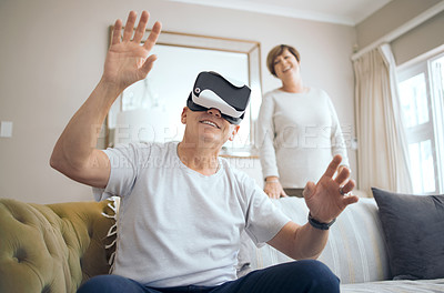 Buy stock photo Shot of a mature man using a VR headset at home