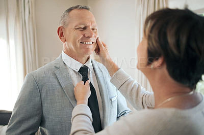 Buy stock photo Shot of a mature woman helping her husband fix his tie