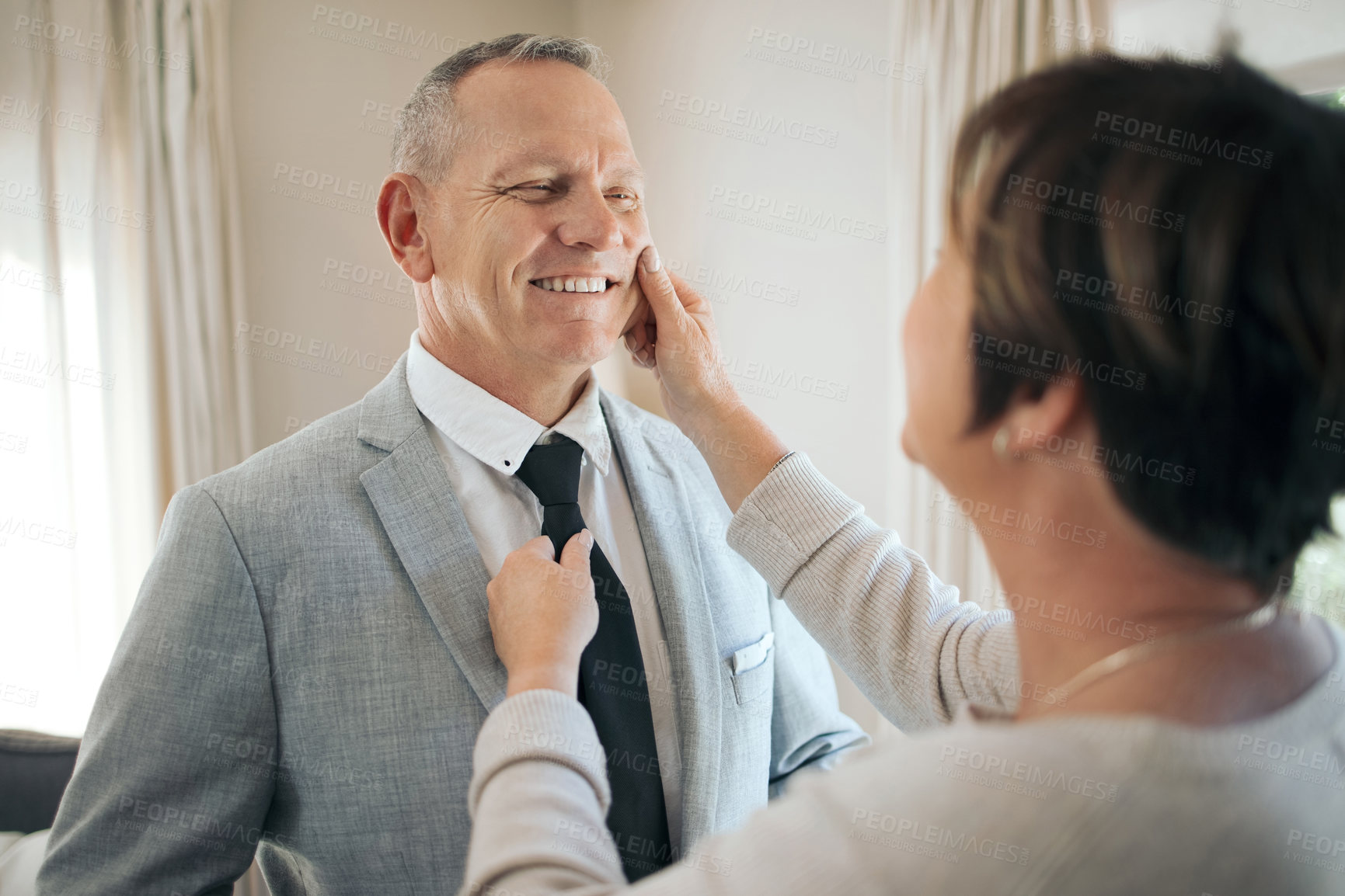 Buy stock photo Shot of a mature woman helping her husband fix his tie