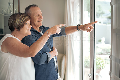 Buy stock photo Shot of a mature couple enjoying the view from their window