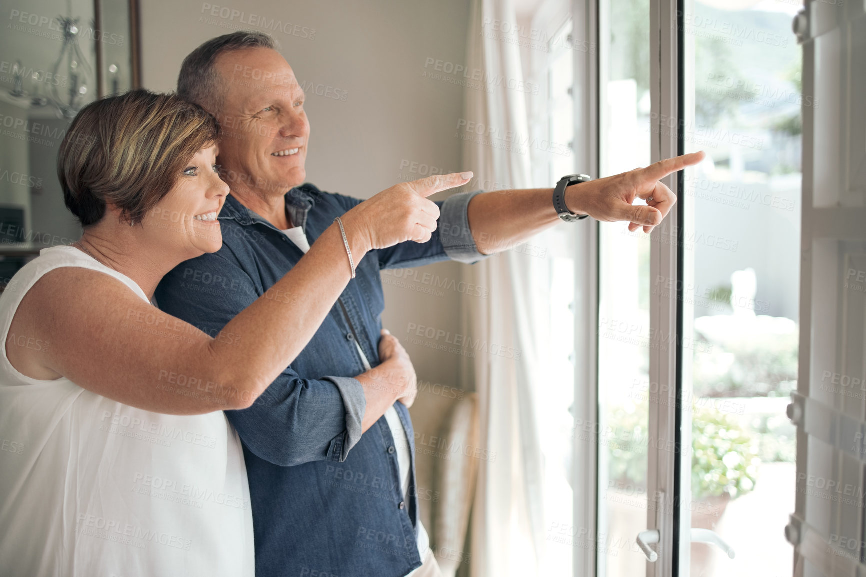 Buy stock photo Shot of a mature couple enjoying the view from their window