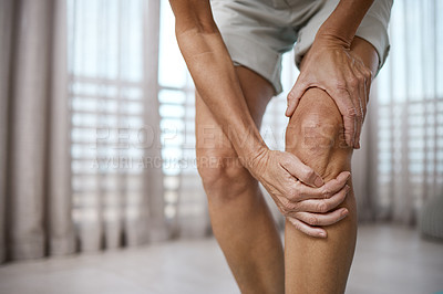 Buy stock photo Cropped closeup of an unrecognizable mature woman experiencing pain in her knee  at home