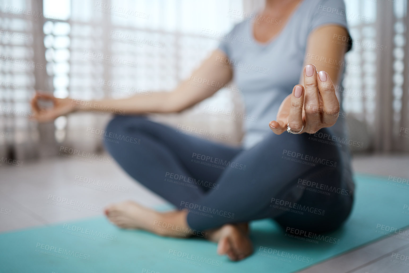 Buy stock photo Cropped shot of an unrecognizable woman meditating on the floor at home