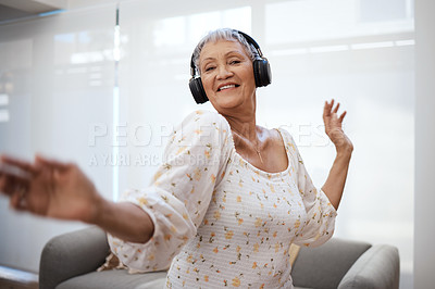 Buy stock photo Shot of a senior woman dancing while using headphones at home