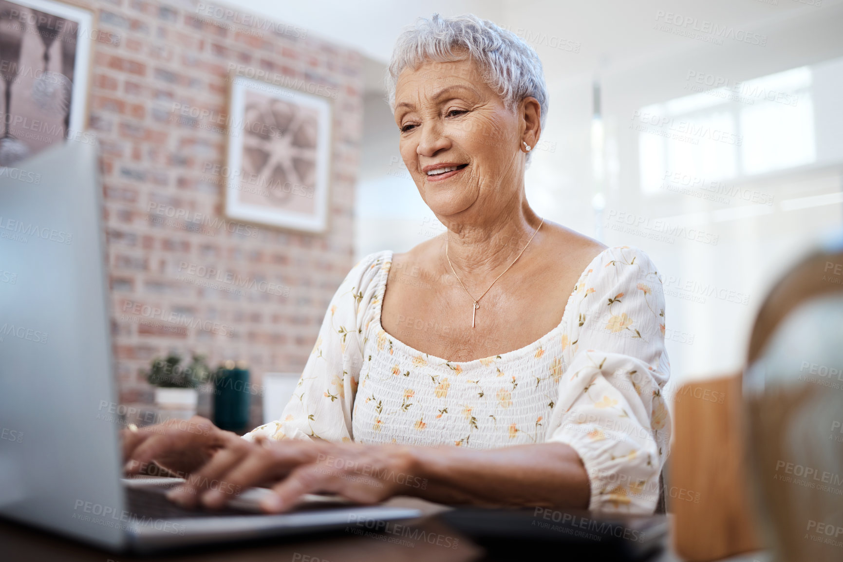 Buy stock photo Shot of a senior woman using a laptop at home