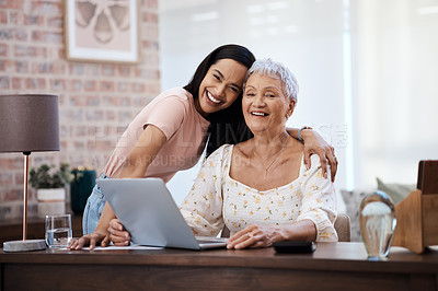 Buy stock photo Shot of a young woman using a laptop with her elderly mother while going through finances at home