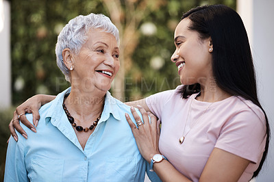 Buy stock photo Shot of a senior woman spending time with her daughter in their garden at home