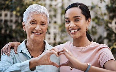Buy stock photo Shot of a senior woman and her daughter making a heart shape with their hands in the garden at home