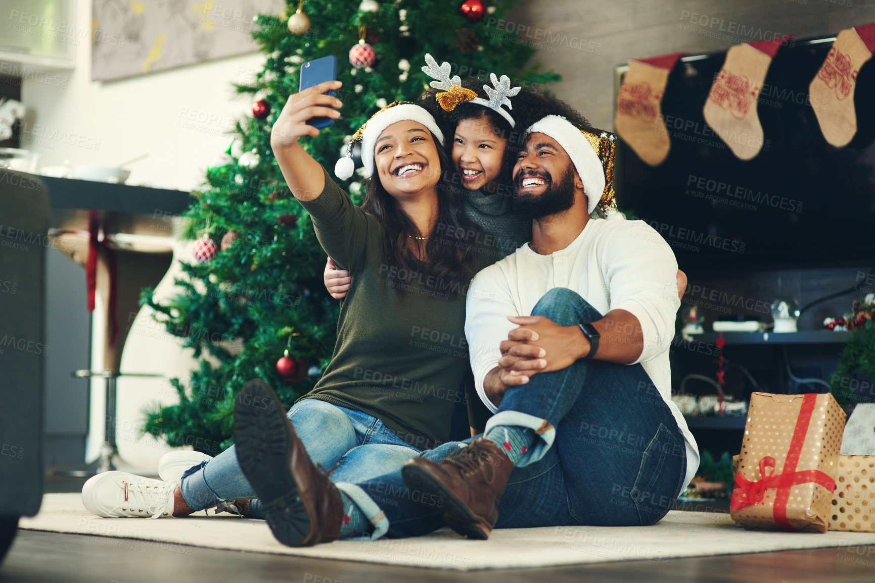 Buy stock photo Christmas selfie, family and happy with holiday and celebration, mother with father and child smile holding smartphone. Christmas tree decoration, gifts and happiness in picture with happy family.