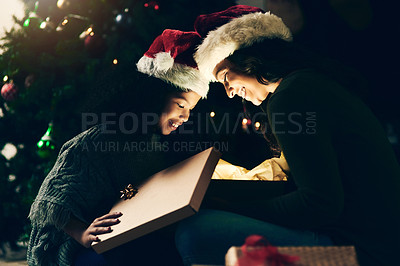 Buy stock photo Christmas, holiday and mother and girl with present opening magic gift box together for festive tradition. Family, love and mom with child on festival, celebration and vacation by Christmas tree