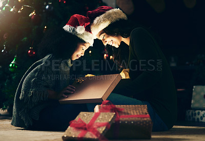 Buy stock photo Mother, child and opening Christmas gift together at night, excited and happy to celebrate holiday with presents. Christmas tree, woman with little girl and gifts on the floor, happy surprise at home