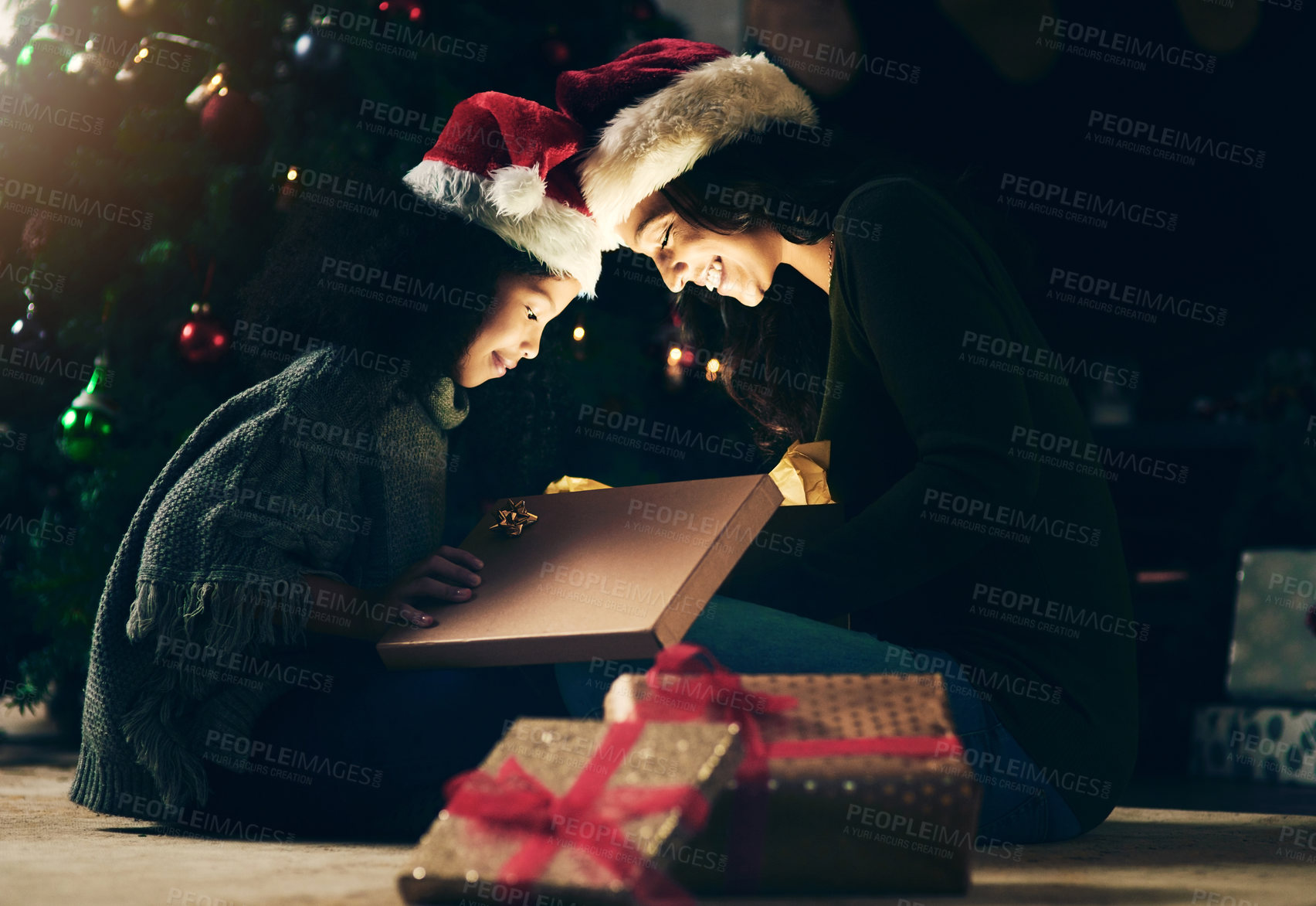 Buy stock photo Mother, child and opening Christmas gift together at night, excited and happy to celebrate holiday with presents. Christmas tree, woman with little girl and gifts on the floor, happy surprise at home