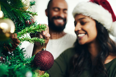Buy stock photo Christmas, decorating tree and happy black couple celebrate holiday season with love, happiness and festive bonding. Black woman, man smile together and enjoy decorate Christmas tree in living room 
