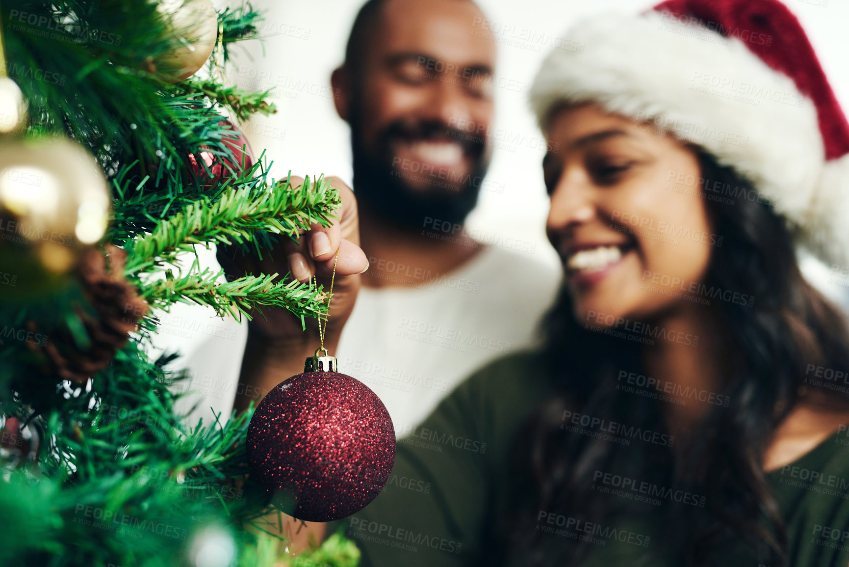 Buy stock photo Christmas, decorating tree and happy black couple celebrate holiday season with love, happiness and festive bonding. Black woman, man smile together and enjoy decorate Christmas tree in living room 
