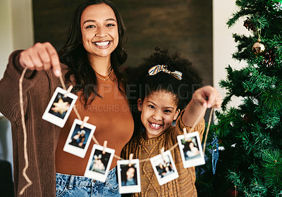 Buy stock photo Christmas, decoration and mother and girl with Polaroid on a tree for love, happiness and celebration of holiday in a house. Festive, happy and portrait of a mom and child show picture for decorating