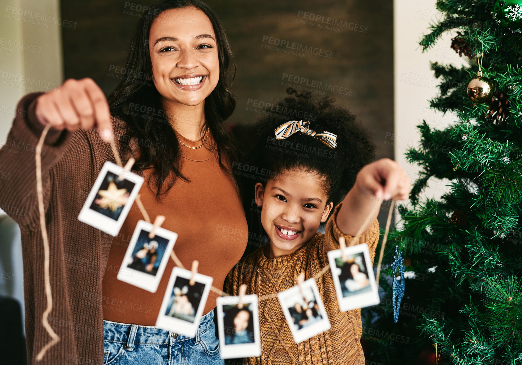 Buy stock photo Christmas, decoration and mother and girl with Polaroid on a tree for love, happiness and celebration of holiday in a house. Festive, happy and portrait of a mom and child show picture for decorating