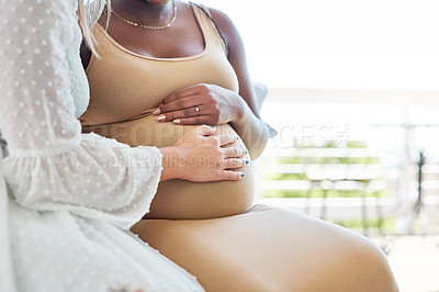 Buy stock photo Shot of a woman touching her friends pregnant belly