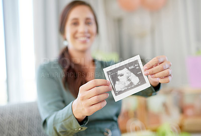 Buy stock photo Shot of a young mother to be holding an ultrasound of her unborn child