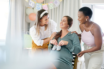 Buy stock photo Shot of a young mother to be holding her babies shoes against her pregnant belly