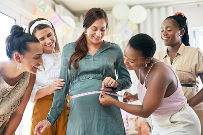 Buy stock photo Shot of a group of women measuring their pregnant friends belly during her baby shower