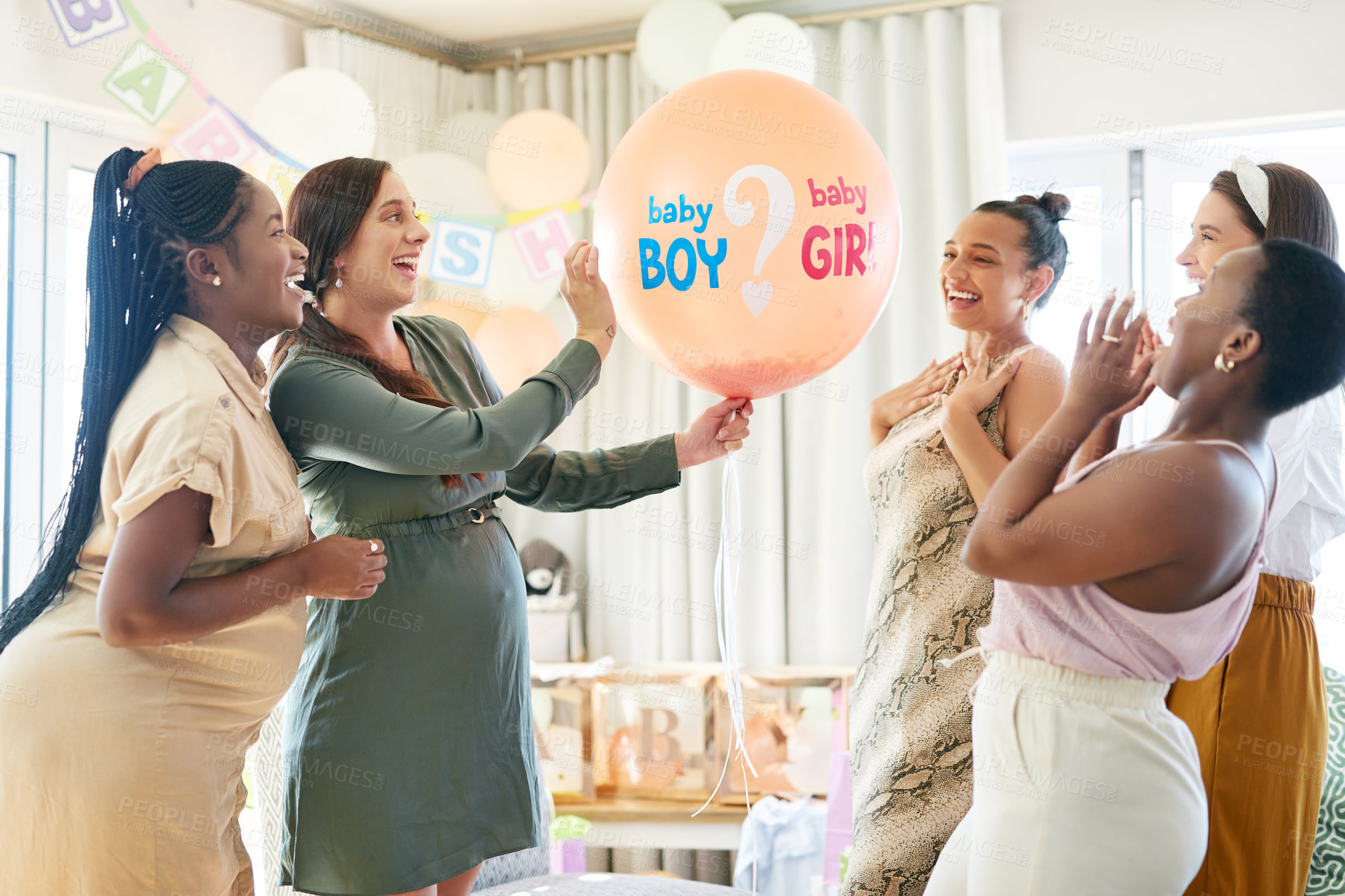 Buy stock photo Shot of a group of women about to pop a balloon for a gender reveal during a baby shower