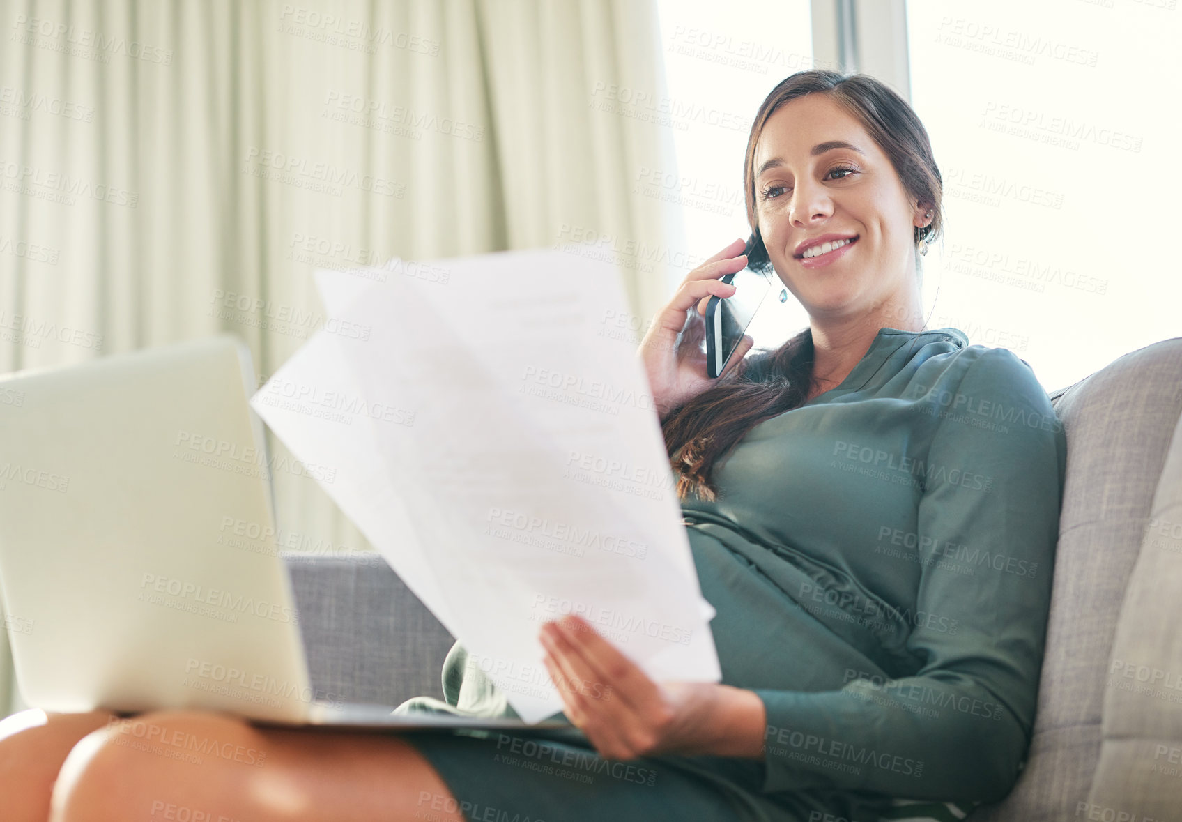 Buy stock photo Shot of a young mother to be working from home using her smartphone