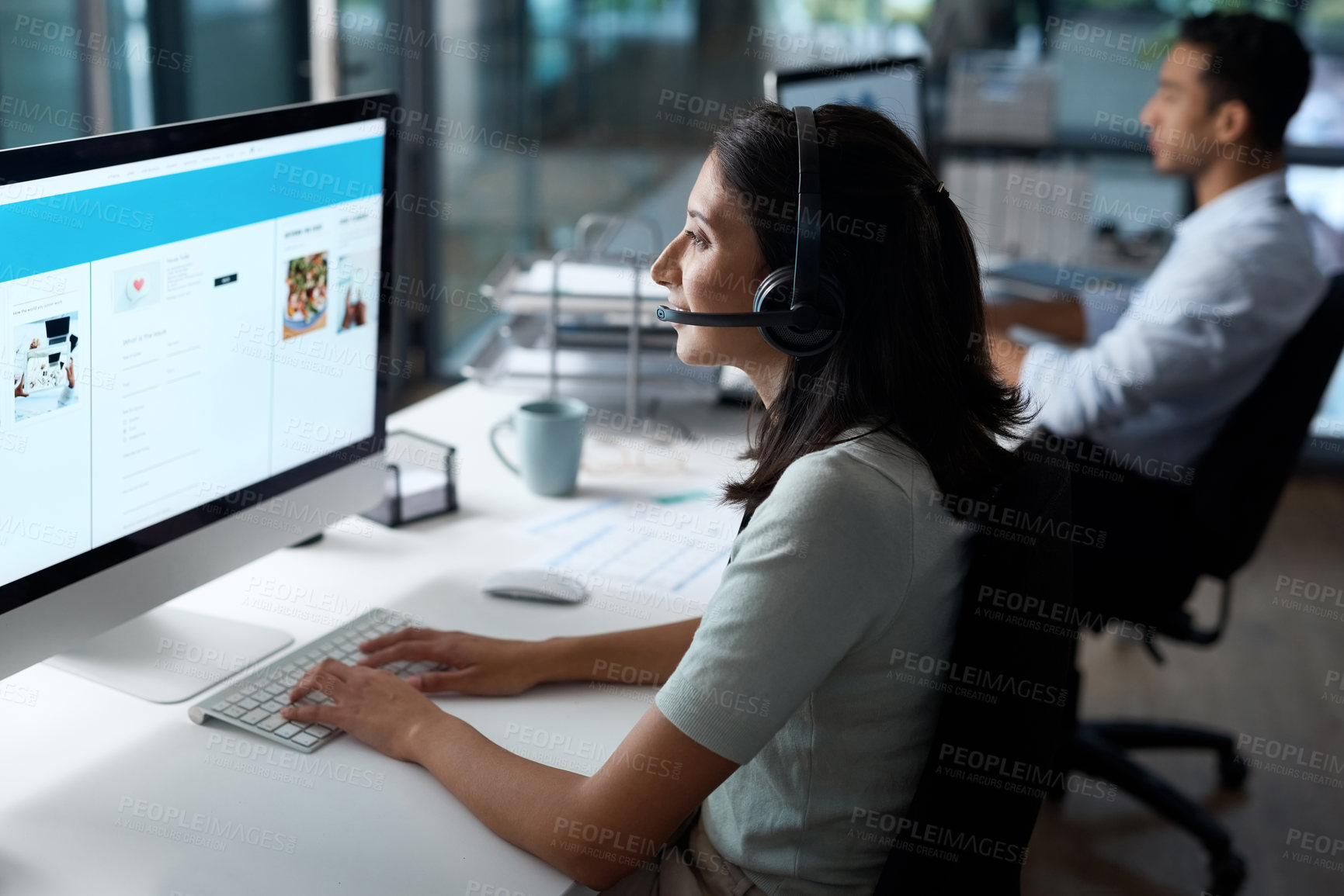 Buy stock photo Shot of a young woman using a headset and computer in a modern office