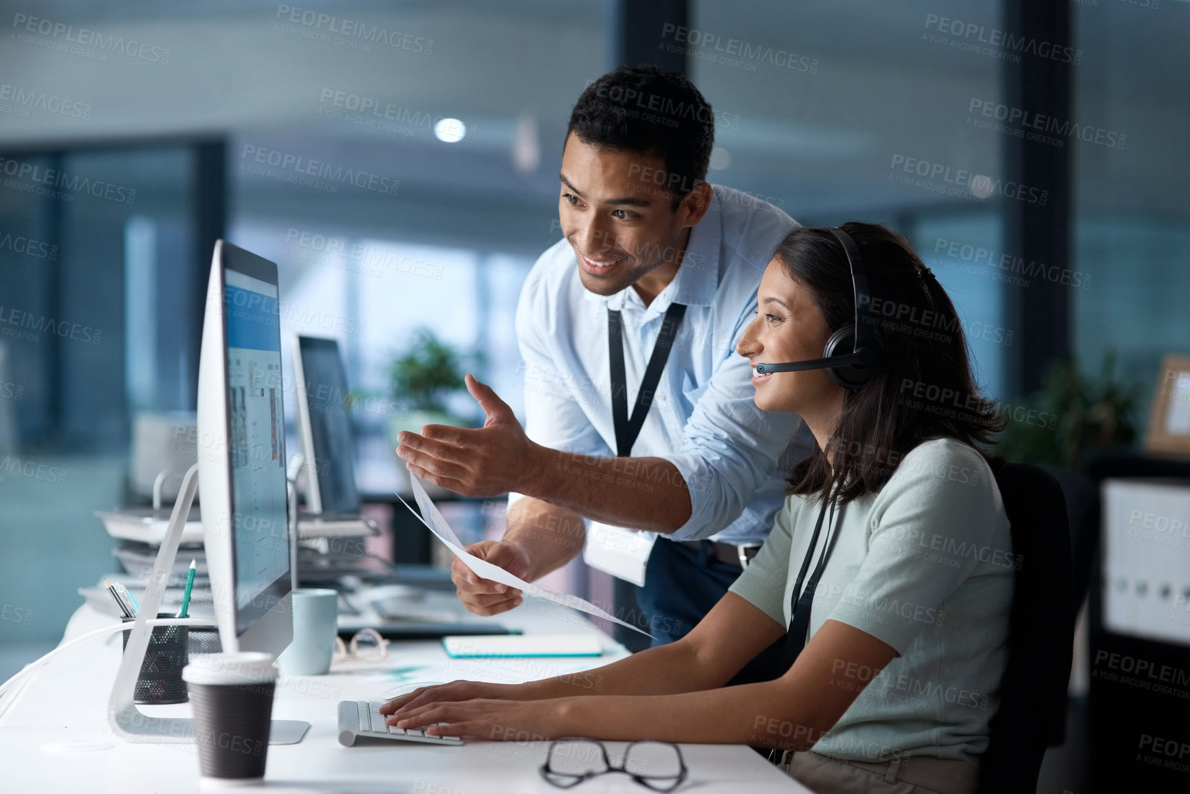 Buy stock photo Shot of a young man and woman using a computer while working in a call centre