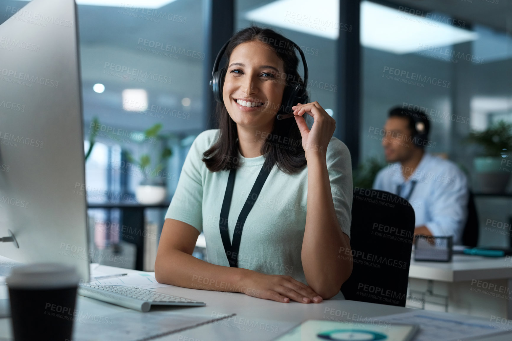 Buy stock photo Portrait of a young woman using a headset and computer in a modern office