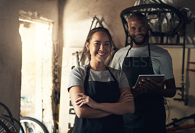 Buy stock photo Portrait of two young people working at a bicycle repair shop