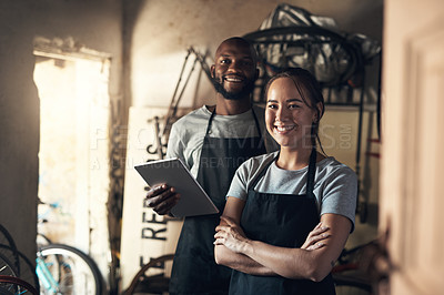 Buy stock photo Portrait of two young people working at a bicycle repair shop