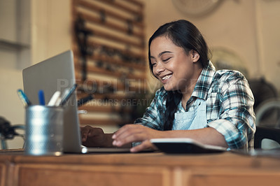 Buy stock photo Shot of a young woman using a laptop at work