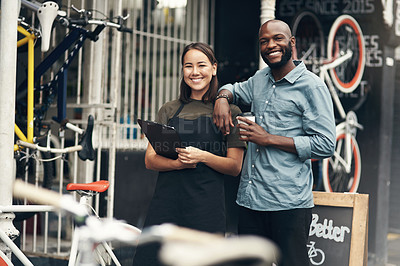 Buy stock photo Shot of two young business owners standing outside their bicycle shop during the day