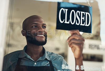 Buy stock photo Shot of a handsome young man standing and turning the sign on the door to his bicycle shop