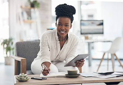 Buy stock photo Shot of a businesswoman using her digital tablet while writing notes