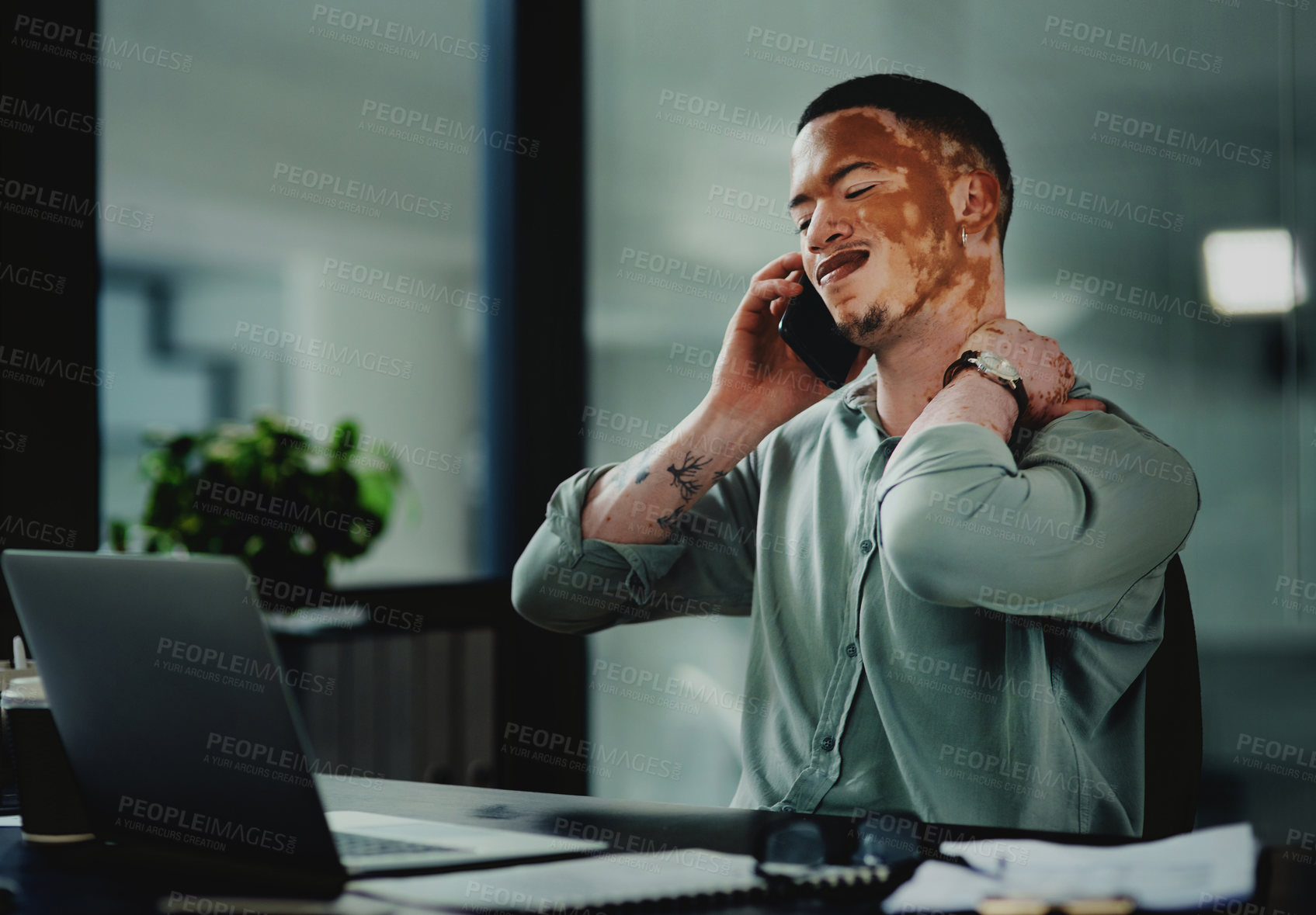 Buy stock photo Shot of a young businessman with neck pain while on a call in an office at work