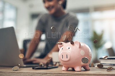 Buy stock photo Financial strategy, investment or finance saving with a piggybank and coins falling out on a desk. Bank cash and money or digital budget growth of a person looking at online banking in the background