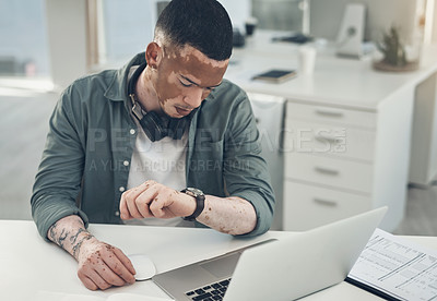 Buy stock photo Shot of a young business man checking his watch in a modern office