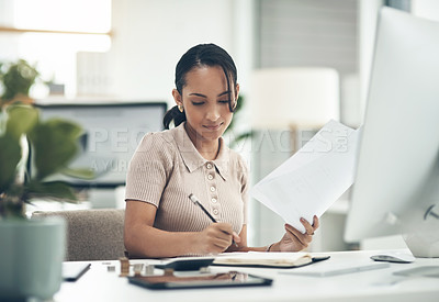 Buy stock photo Shot of a young businesswoman calculating finances in an office
