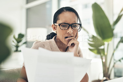 Buy stock photo Shot of a young businesswoman looking stressed out while going through paperwork in an office