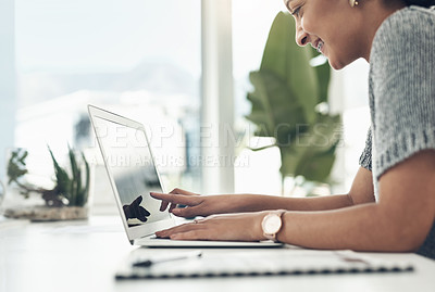 Buy stock photo Shot of a young businesswoman working on a laptop in an office