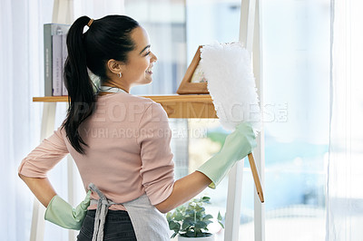 Buy stock photo Shot of a woman holding a duster while doing chores at home