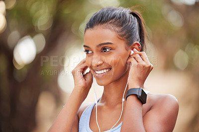 Buy stock photo Fitness, earphones and Indian woman in park for running, training or morning cardio with music. Sports, smile and happy runner in forest for exercise, workout and streaming podcast for run motivation