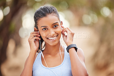 Buy stock photo Portrait, woman and exercise with earphones in nature for workout, fitness watch and audio listening. Indian athlete, music and health in forest with wearable tech, streaming podcast and sports run