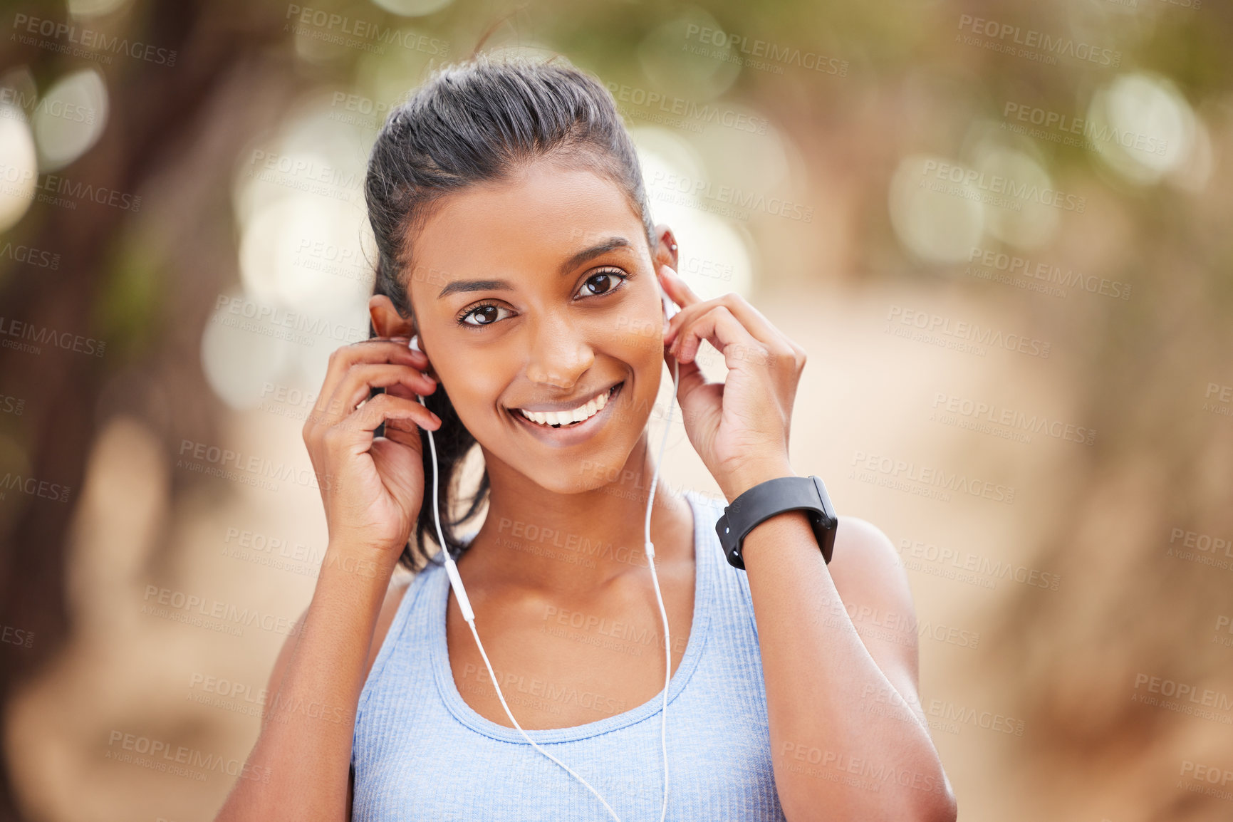 Buy stock photo Portrait, woman and exercise with earphones in nature for workout, fitness watch and audio listening. Indian athlete, music and health in forest with wearable tech, streaming podcast and sports run