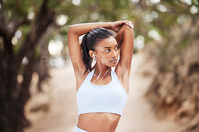 Buy stock photo Shot of a young woman stretching before a jog