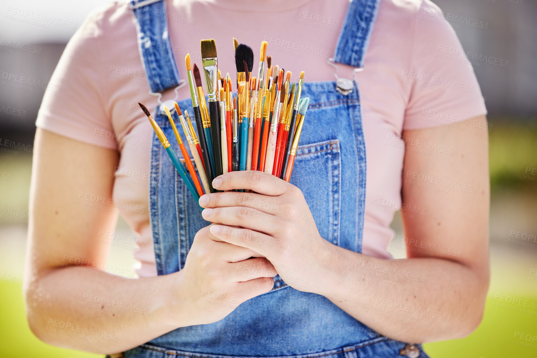 Buy stock photo Cropped portrait of an unrecognizable young woman painting in the park
